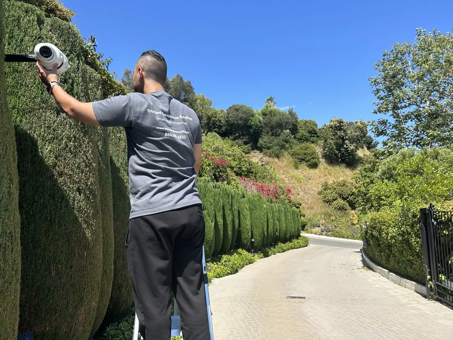 Three Factor Security technician aligning a residential perimeter camera for remote event verification — Three Factor Security fieldwork in Hidden Hills